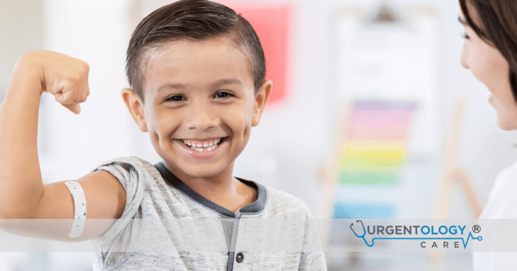 boy holding up and flexing his arm at the doctor